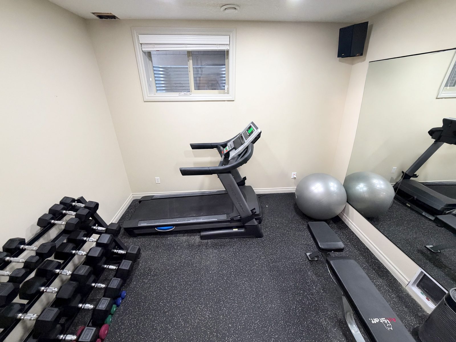 Fitness room with rubber flooring and a mirror wall