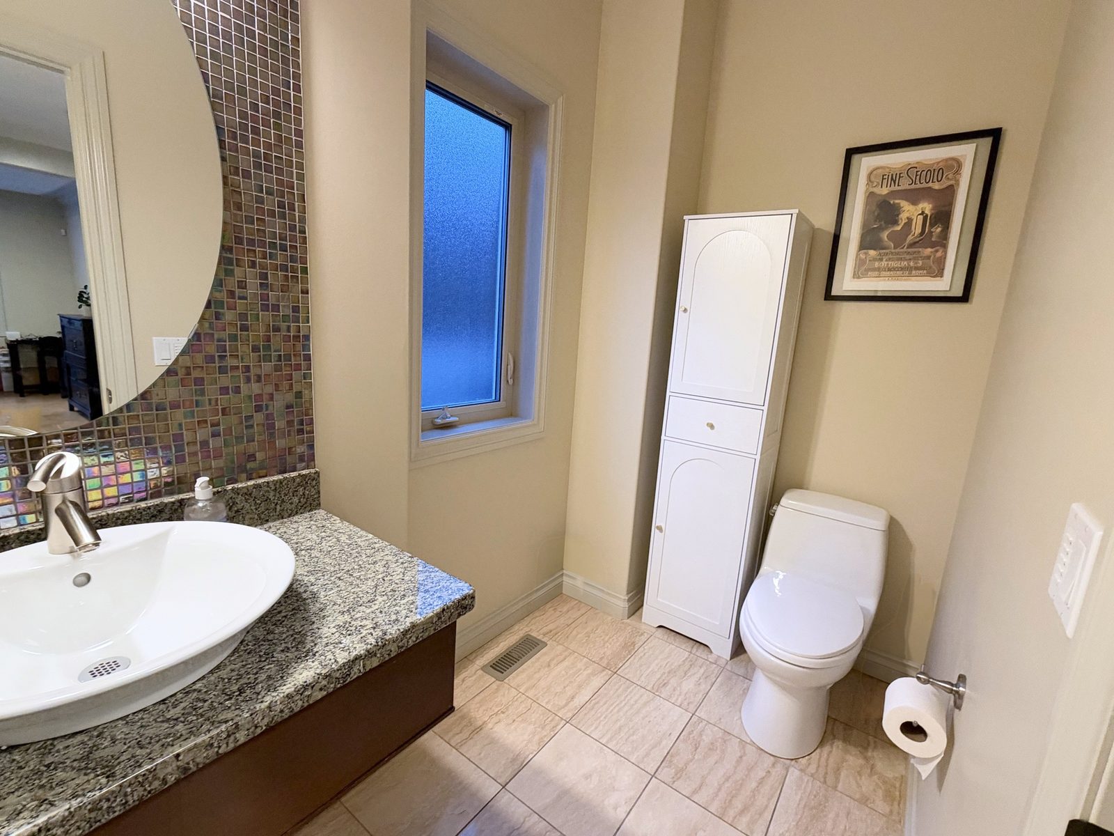 Main-floor powder room with vessel sink and glass mosaic tile