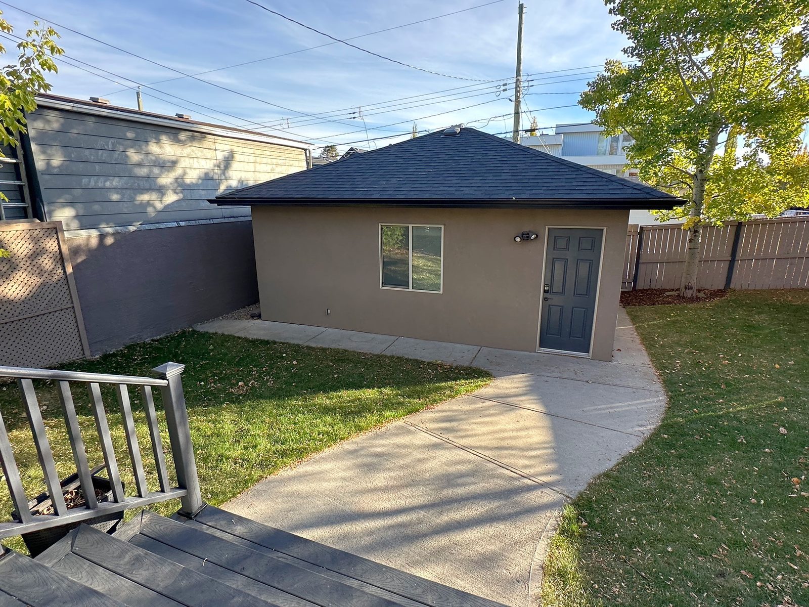 Detached double garage with a side door, reached by a concrete walkway