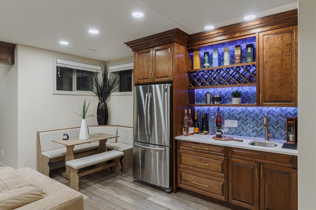 Wet bar with wine rack, herringbone tile and a full-size fridge